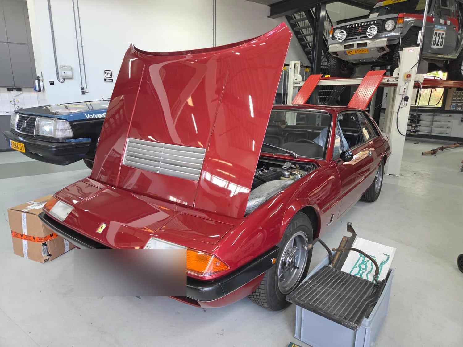 Ferrari 365 GT4 V12 in de werkplaats, met geopende motorkap